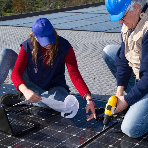 Two women installing solar panels