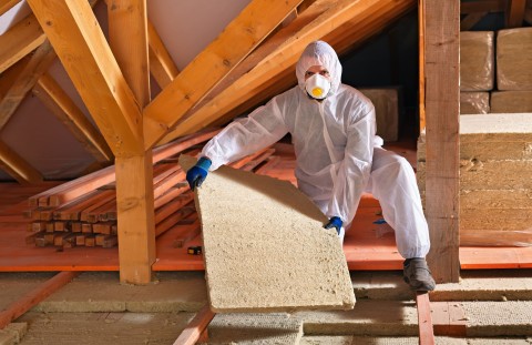 image of person in PPE laying down floor material