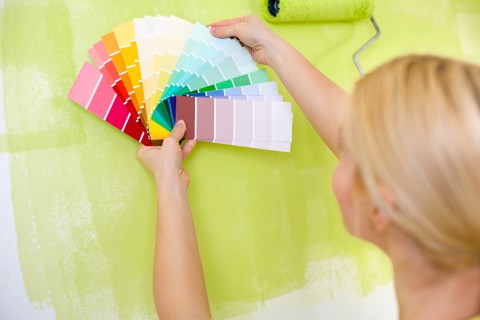 close up image of woman holding wall colors up the wall